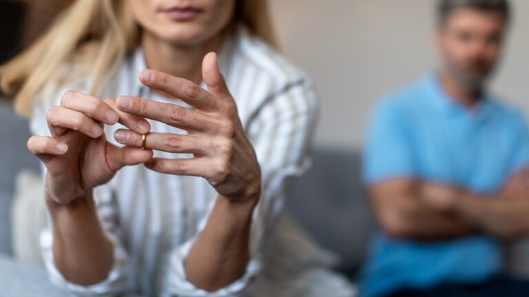 sad woman takes off her wedding ring