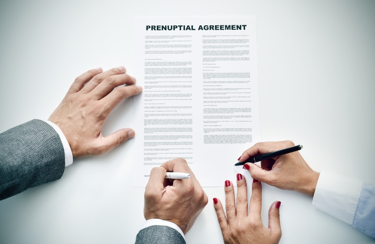 man and woman signing prenuptial agreement