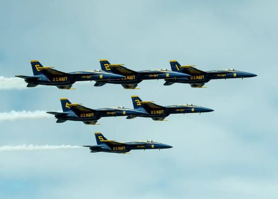 Several blue and yellow jets flying in tight formation, creating a striking aerial display.