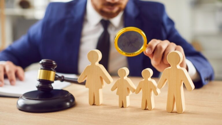 Judge examines wooden figures of a family in a courtroom