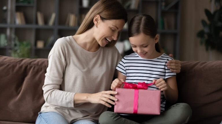 Curious little preteen kid girl unwrapping gift box