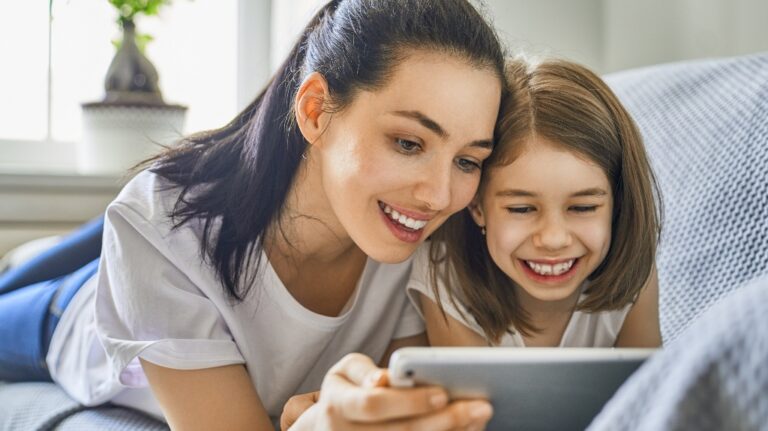 Young mother and her daughter girl are looking at the tablet