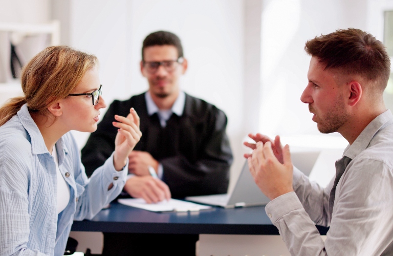 divorced couple talking to each other in lawyer's office