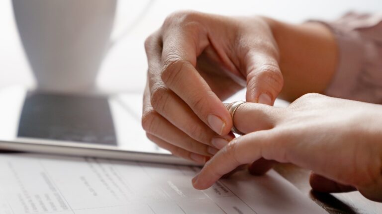 woman is removing wedding ring from her finger