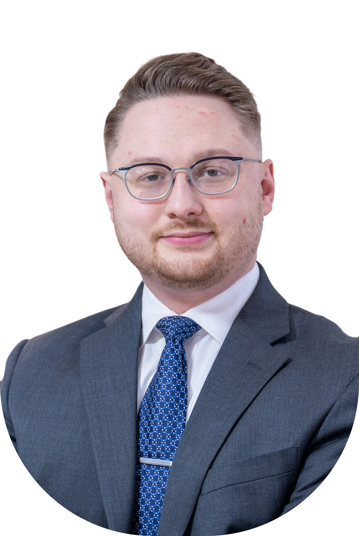 Professional young man with glasses, short styled hair, gray suit, white shirt, and blue patterned tie.
