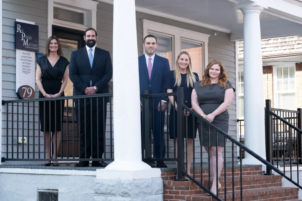 Five professionally dressed individuals standing on a porch outside Rice Posner Mastracci law office.